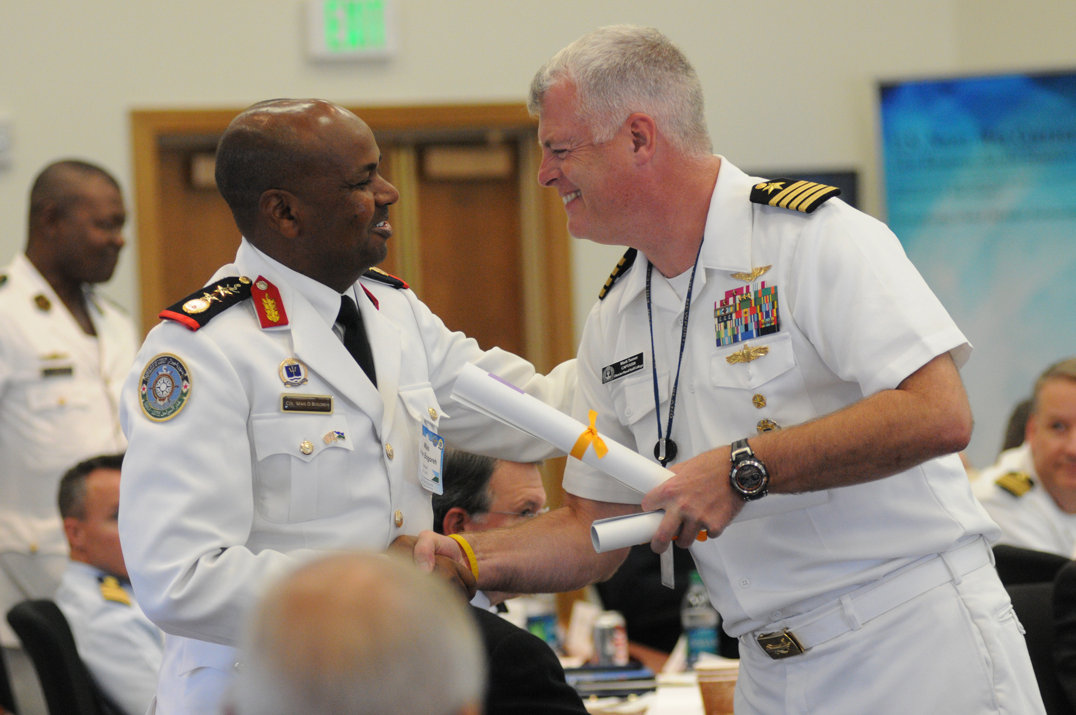 150827-N-XT779-035 NEWPORT, R.I. (Aug. 27, 2015) Capt. Mark Turner, director, Naval Staff College, U.S Naval War College (NWC), presents Djibouti coast guard Col. Wais O. Bogoreh, a NWC alumnus, with a commemorative gift during NWC's 12th Regional Alumni Symposium-Africa, held at NWC in Newport, Rhode Island. The event, co-hosted by U.S. Naval Forces Europe-Africa and U.S. 6th Fleet and sponsored by U.S. Africa Command, served as an opportunity to strengthen global maritime partnerships and address strategic, operational and technical issues of relevance to the Africa region. Thirty-eight international NWC alumni from 22 countries in Africa, Europe and South America were in attendance. (U.S. Navy photo by Ezra Bolender/Released)